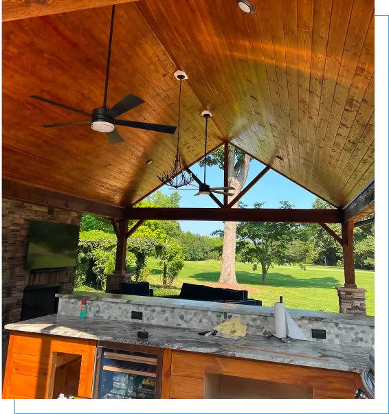 Outdoor patio with ceiling fans and greenery.