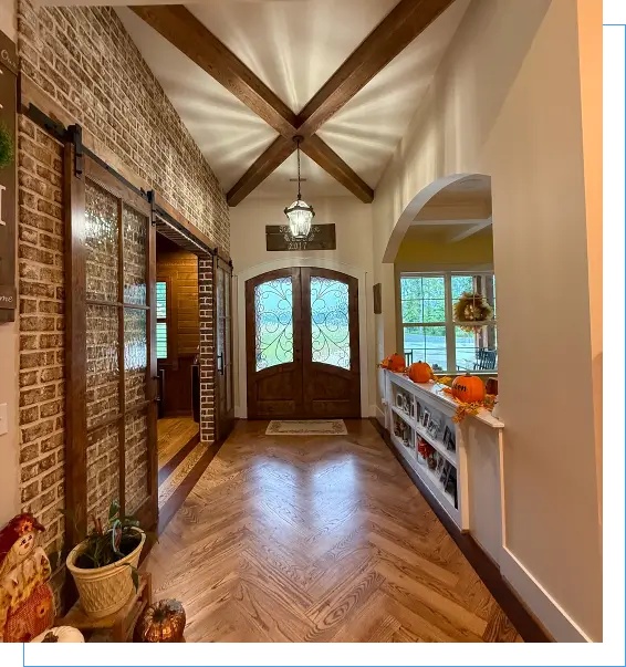 Rustic entryway with wooden doors and pumpkins.