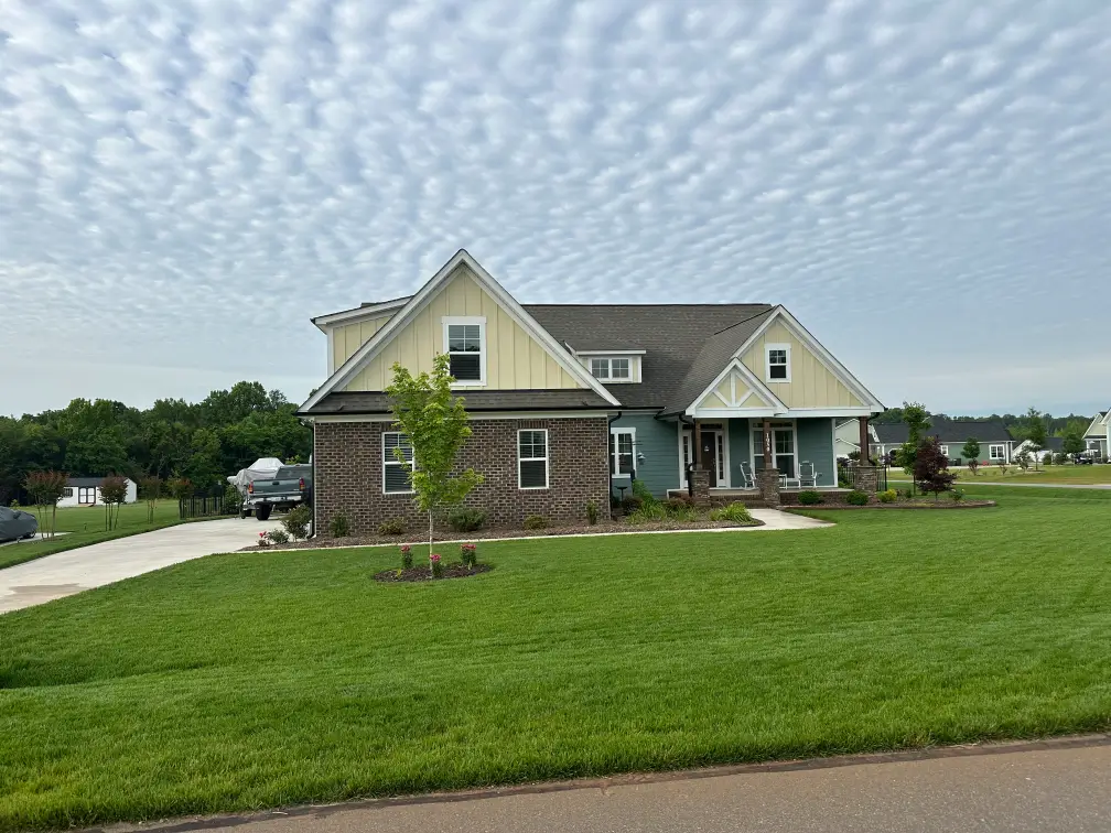 Modern house with a large green lawn.